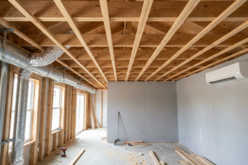 Home under construction timber ceiling frame, ductwork left, split system right